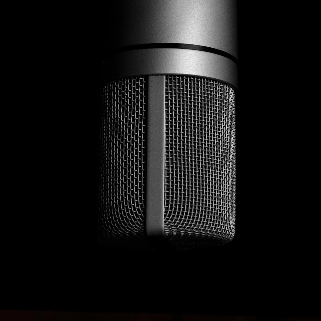 Detailed close-up shot of a metallic studio microphone on a black background, emphasizing sound recording equipment.